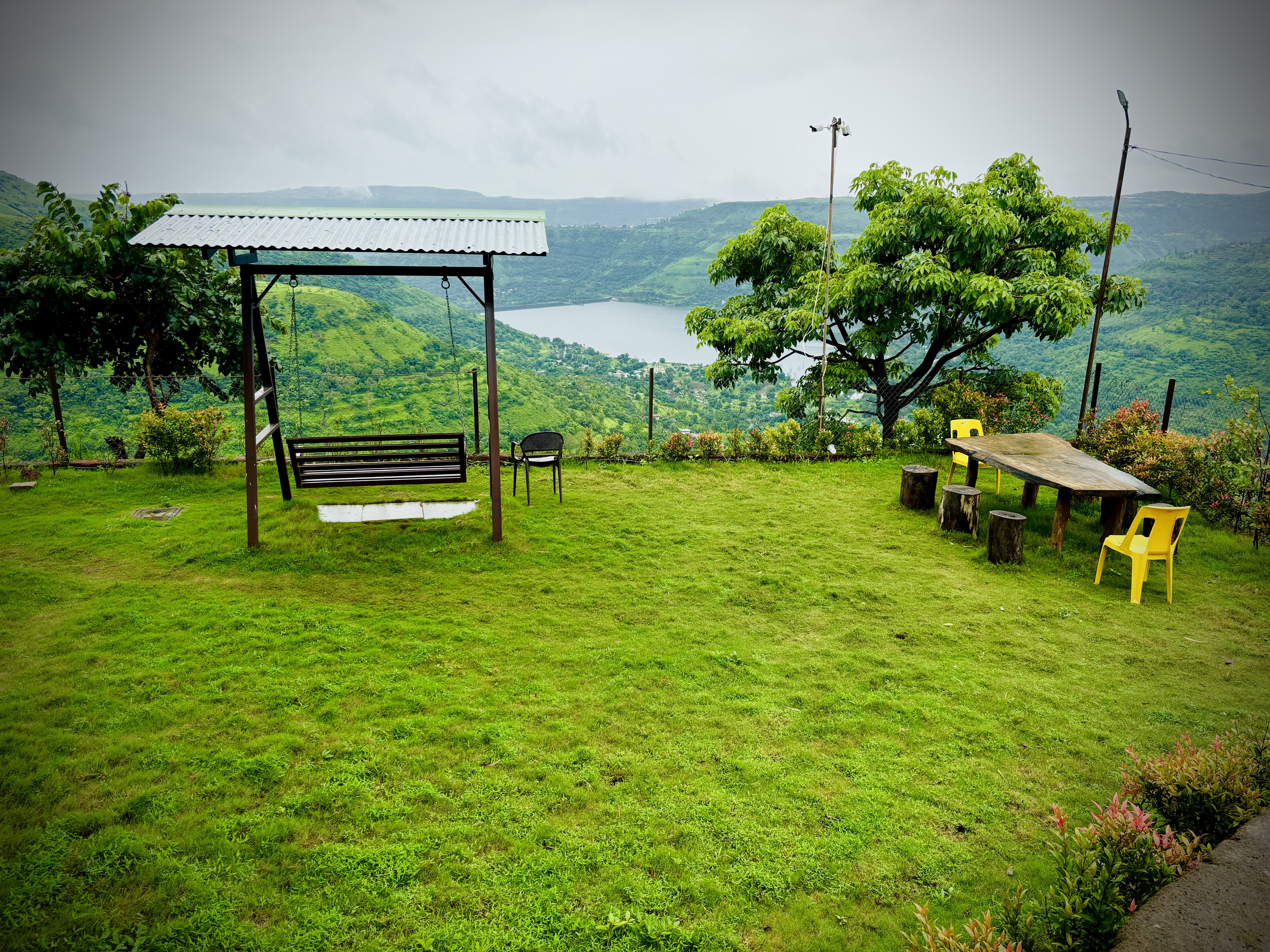 Garden lawn with swing and dam view at Paramount's Vinayaka — perfect for families