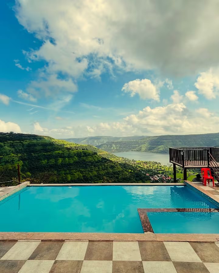 Infinity pool with blue sky and Mahu Dam view at Paramount's Vinayaka Homestay