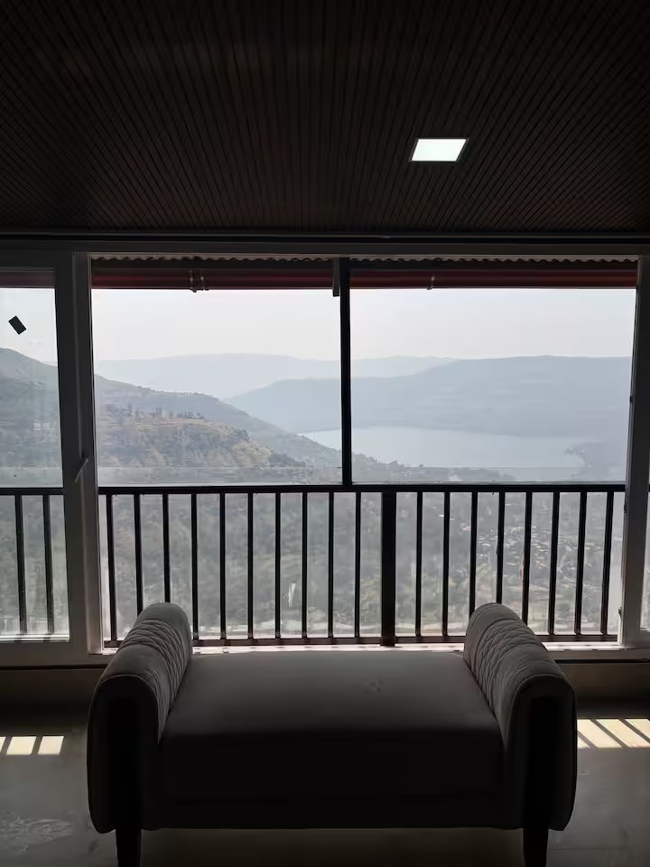 Room with valley and dam view through window at Paramount's Vinayaka