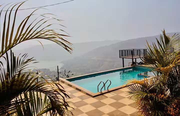 Pool through palm trees at Paramount's Vinayaka Panchgani